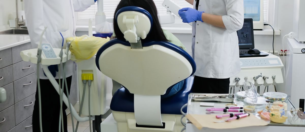 Profesionales sanitarios junto a un paciente en un gabinete dental
